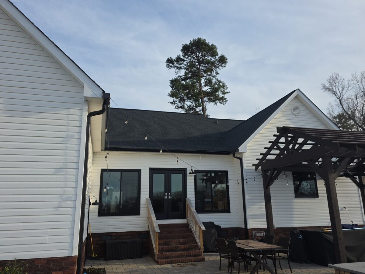 White farmhouse with dark architectural shingle roof