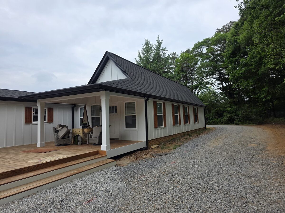 Board and batten farmhouse with new porch and shingle roof